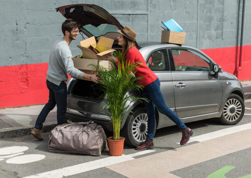 Man and woman moving boxes into car