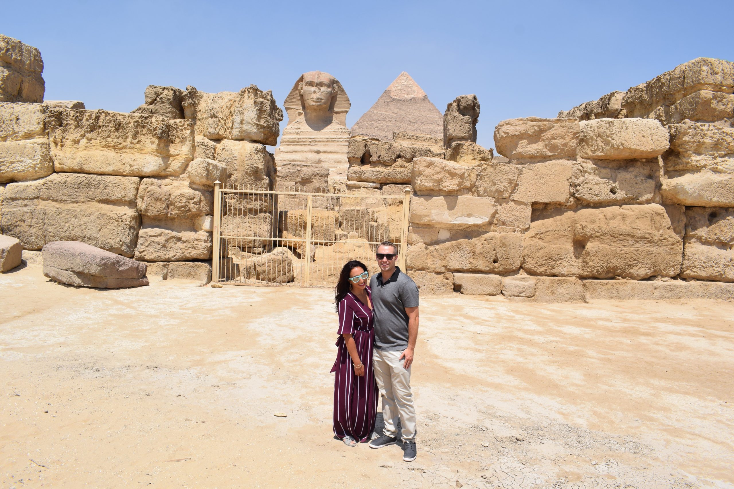 Boy and Girl standing in front of Sphinx and Pyramids of Giza
