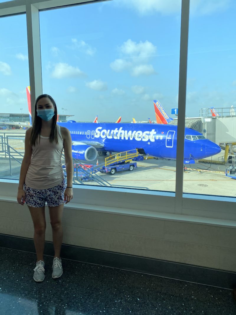 Girl with mask on and Southwest Airplane in the background