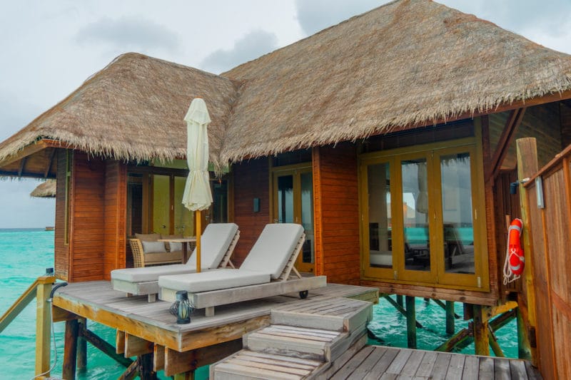 Overwater Bungalow with lounge chairs Hilton Conrad Maldives