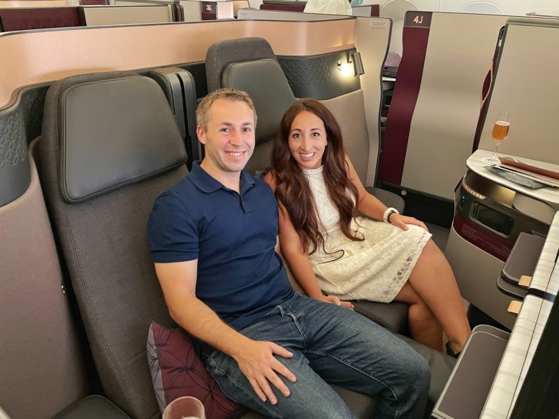 Couple enjoying business class seats on Qatar Airways, "Q-Suites" flight.