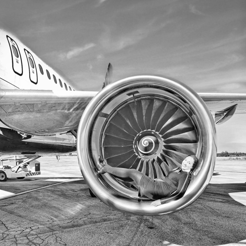 Woman posing laying on an airplane engine