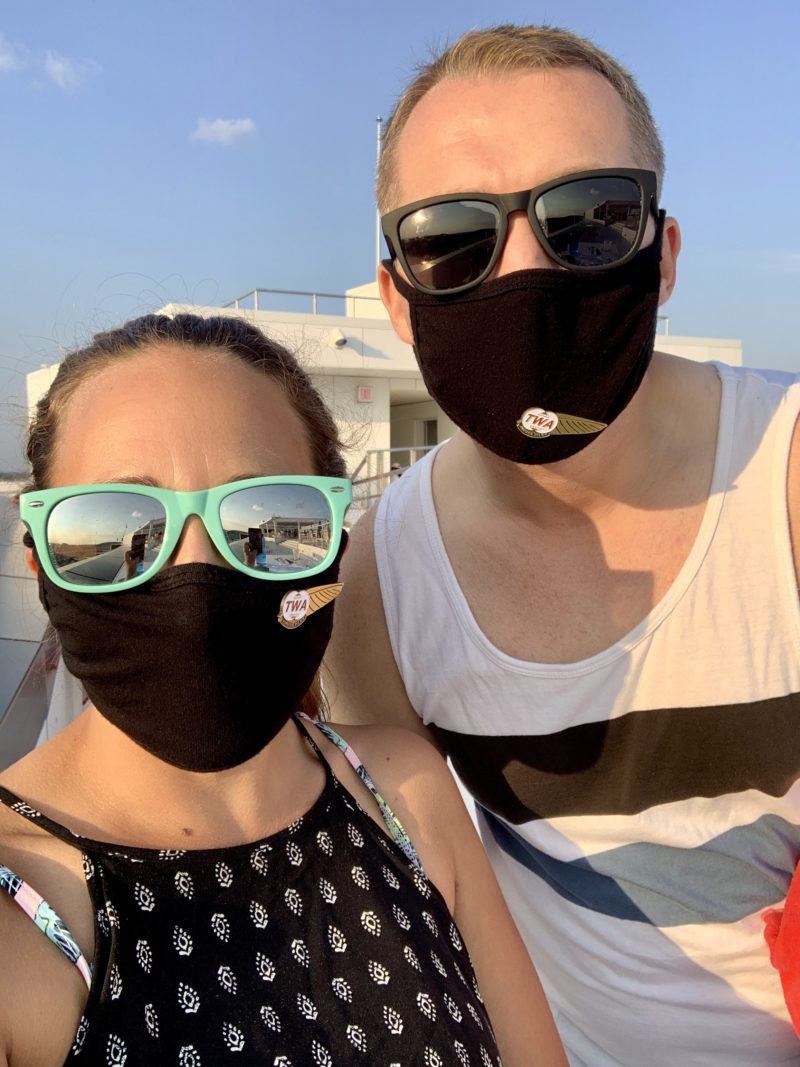 Man and Women in black face-masks and TWA wings attached