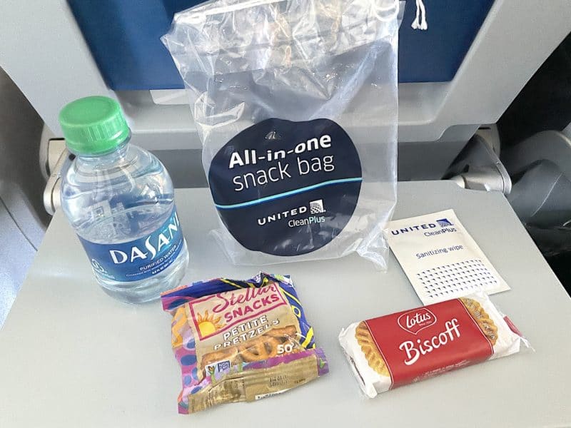 United's All in One snack bag with water, pretzels, Biscoff cookies, and sanitizer wipes.