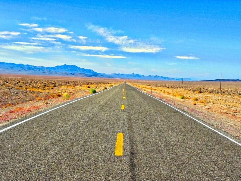 Picture of the open read with mountains in the background and desert on both sides