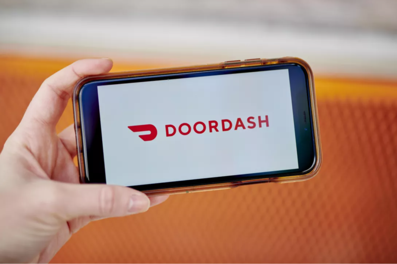 Cell phone being held in someones hand with the DoorDash app open