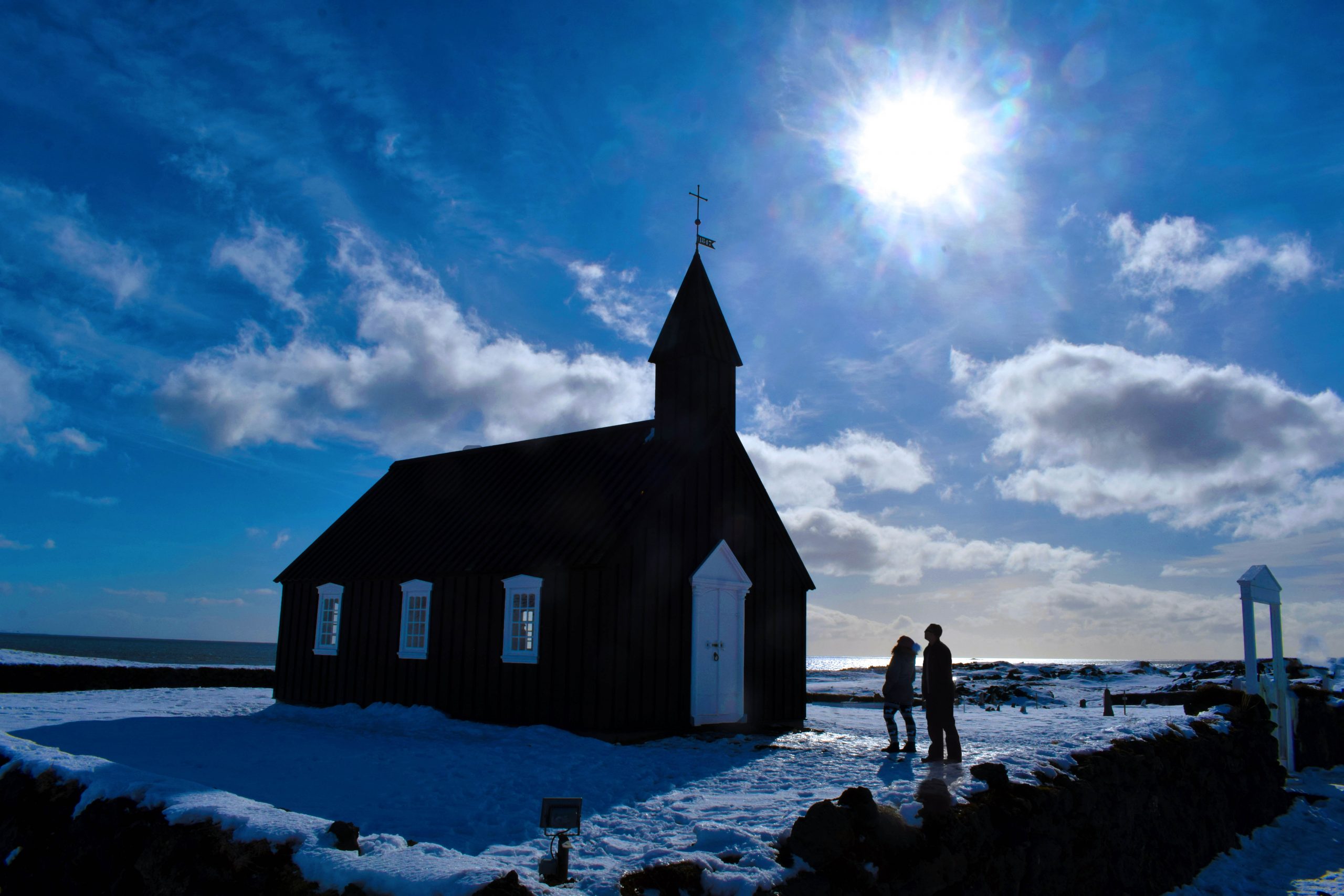 Couple admiring black church at Buðir